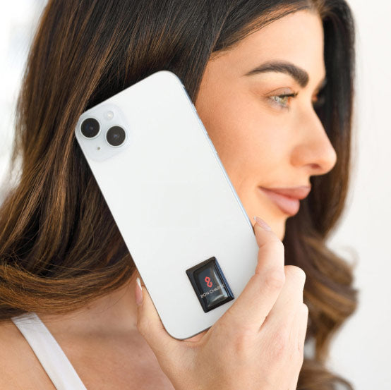 Woman holding up phone to ear with EMF Sticker on device