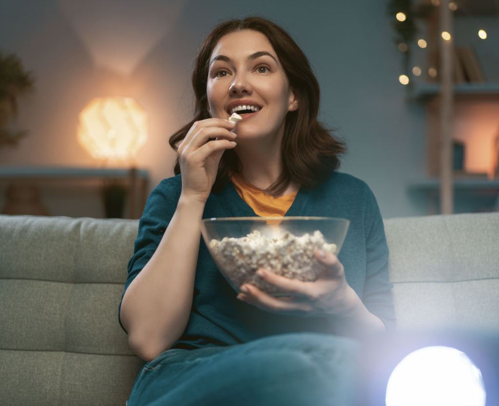 Woman Eating Popcorn Sitting On Sofa