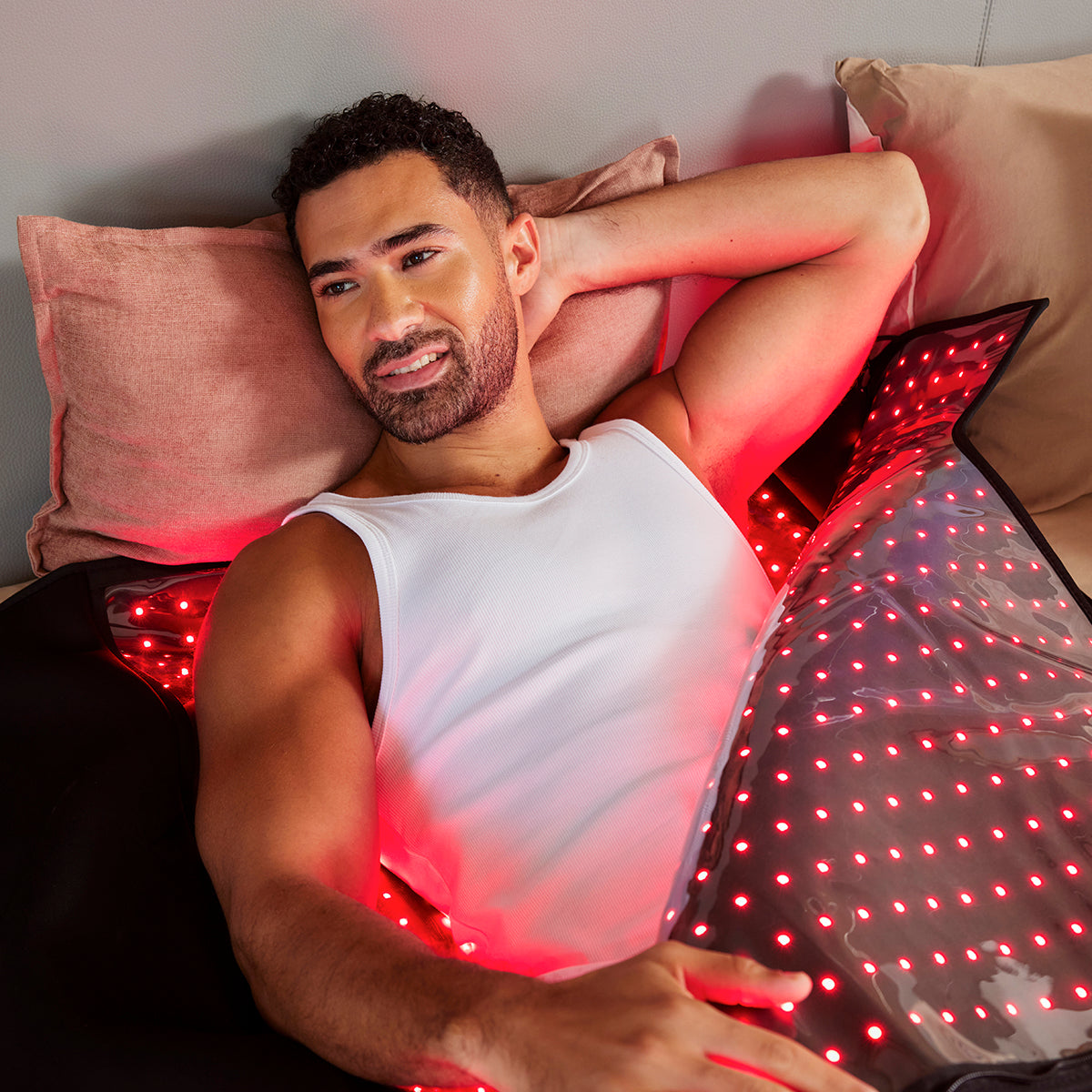 Man resting under the blanket with rows of red LEDs lighting his body