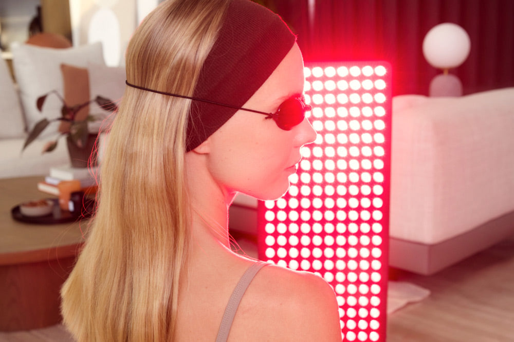 Woman in Front of Red Light Panel Wearing Goggles