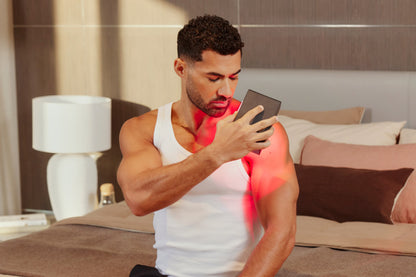 Man Applying Mini Red Light Therapy Device To Shoulder