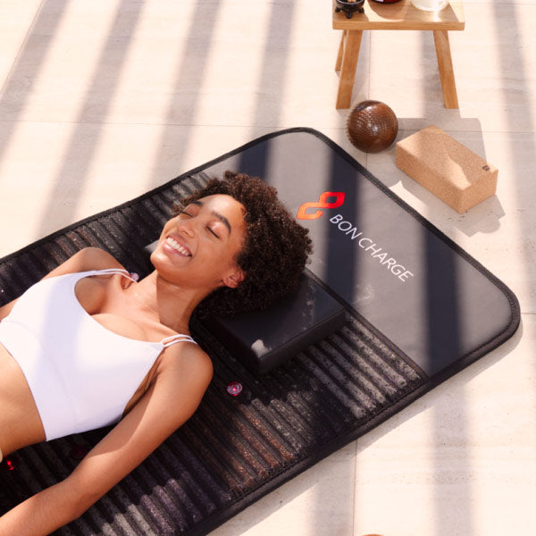 Woman Smiling Laying On PEMF Mat