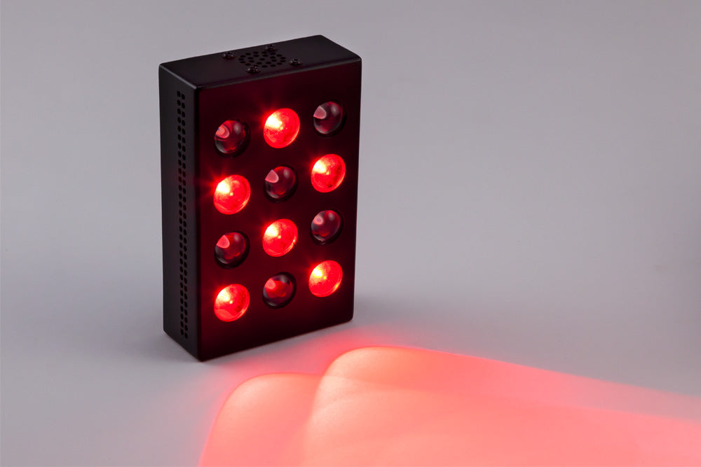 Mini Red Light Therapy Device Glowing on Surface