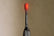 Black electric toothbrush head with red bristles on a beige background